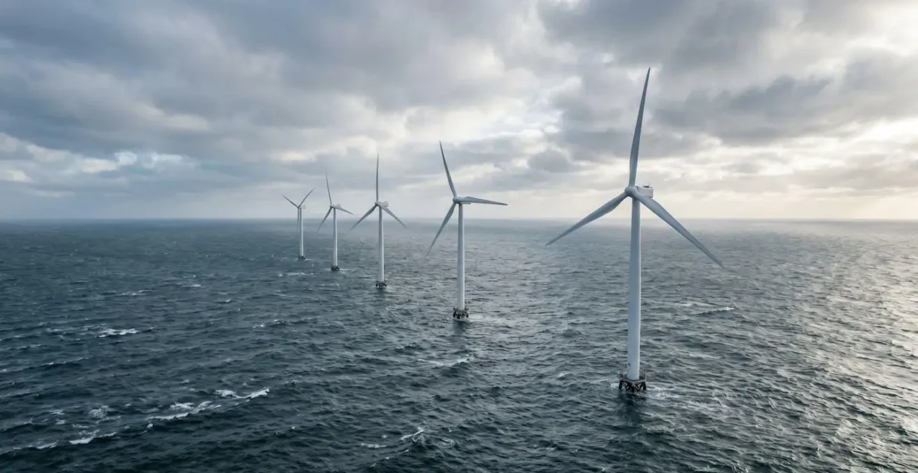 Parc éolien offshore en Mer du Nord avec plusieurs turbines modernes sous un ciel dynamique