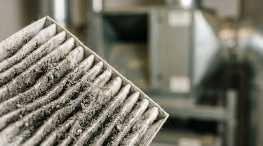 Système de ventilation VMC double flux avec filtre encrassé nécessitant un entretien, illustrant l'impact financier de la négligence de la maintenance HVAC